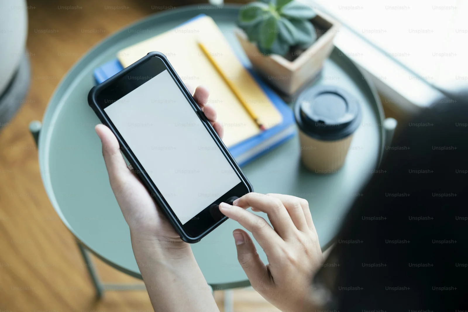 Hands interacting with a smartphone prototype at a desk