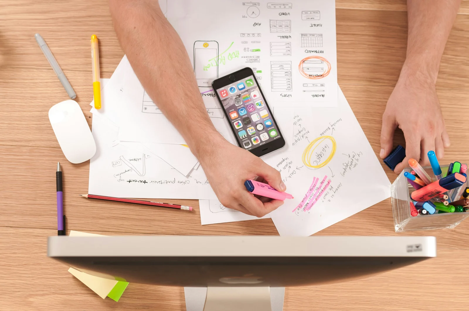 A person planning a mobile experience with notes and a smartphone